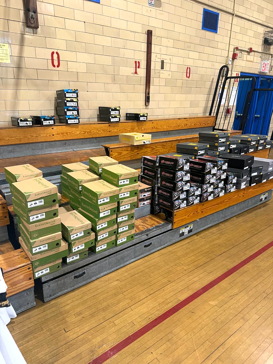 Stacks of new shoe boxes sorted on gym bleachers.